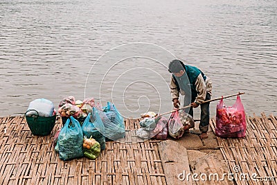 Man Waiting Boat for Moving Commodities in The River at Luang Prabang, Laos Editorial Stock Photo