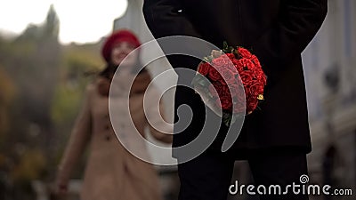 Man waiting for girlfriend, holding flowers, first date, beginning of relations Stock Photo