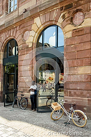 Man waiting outside Apple Store near vintage bike Editorial Stock Photo