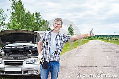 Man waiting to help and showing thumbs up near car Stock Photo