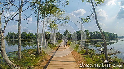 A Man walk on the path through the Great Lake at Angkor Thom Temple Editorial Stock Photo