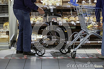Man with a walker for elderly people shopping for groceries in a supermarket during coronavirus covid-19 pandemic Editorial Stock Photo