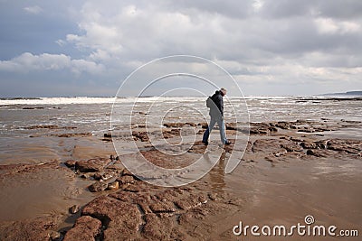 Man walking along Scarborough beach Editorial Stock Photo