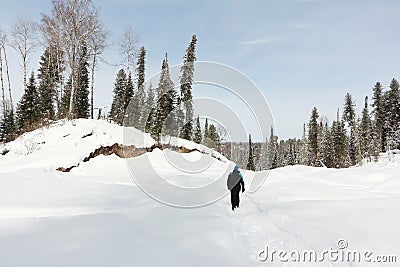 Man walking along a snowy trail, Altai Republic, Russia Stock Photo