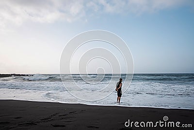 man walking on beach, cloudy weather, beautiful waves of ocean Stock Photo