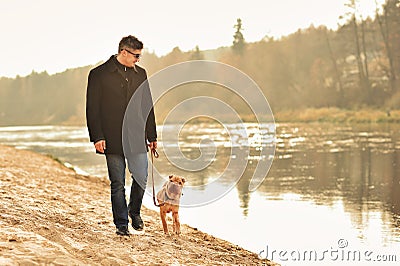 Man walking with dog near the river Stock Photo