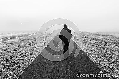 Man walking on an empty desolate raod Stock Photo