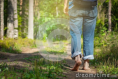 Man walking on footpath forest. Close-up of bare feet soiled with ground. healthy lifestyle. Stock Photo