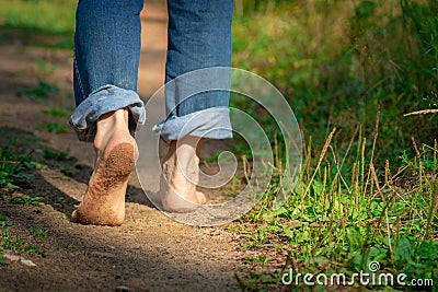 Man walking on footpath forest. Close-up of bare feet soiled with ground. healthy lifestyle. Stock Photo