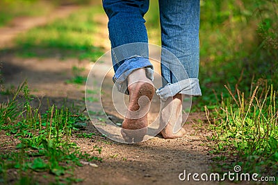 Man walking on footpath forest. Close-up of bare feet soiled with ground. healthy lifestyle. Stock Photo