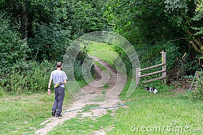 Man walking his dog in the countryside on a Sunday afternoon in summer Editorial Stock Photo