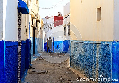 Man walking in the small streets in blue and white in the kasbah of the old city Rabat in Marocco Editorial Stock Photo