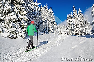 Man walking with snow shoes on winter hiking trail Stock Photo