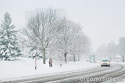 Man walking under snow. Heavy snowfall and snowstorm in Toronto, Ontario, Canada. Snow blizzard and bad weather winter condition. Stock Photo