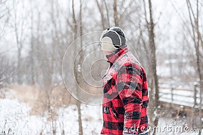 Man walking through woods on a snowy day Stock Photo