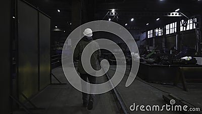 Man walks around factory and looks around. Clip. Foreman oversees work and production of all parts of plant. Engineer or Stock Photo
