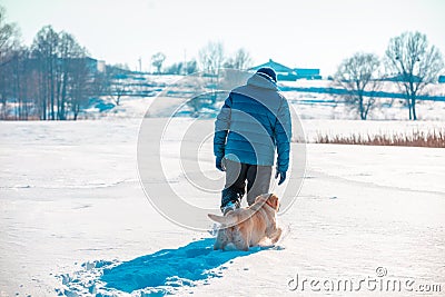 A man walks with a dog in deep snow Stock Photo