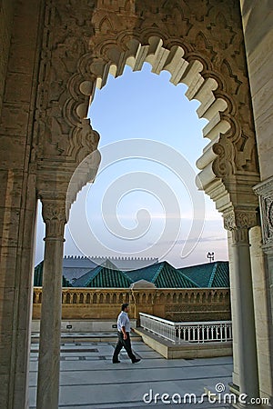 A man walks past an arch of the Mausoleum of Mohammed V on the Y Editorial Stock Photo