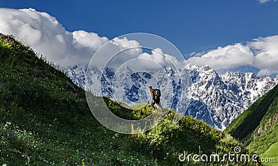 Man walks on a slope against the backdrop of Mount Shkhara, Uzhguli, Svaneti, Georgia Editorial Stock Photo
