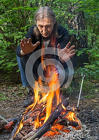 Man is warming his hands at the fire Stock Photo