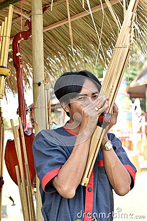 A man was playing a kind of reed mouth organ in northeastern Thailand called Khan. Editorial Stock Photo