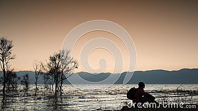 Man was sitting by the erhai lake Stock Photo