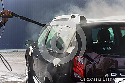 A man washes a brown car, a man washes a car at a contactless car wash Editorial Stock Photo