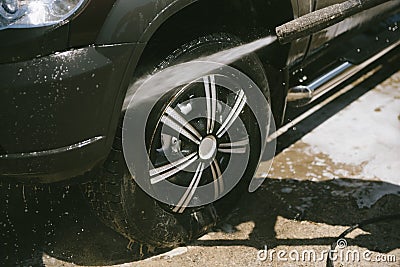 A man washes a car with a high pressure washer Stock Photo