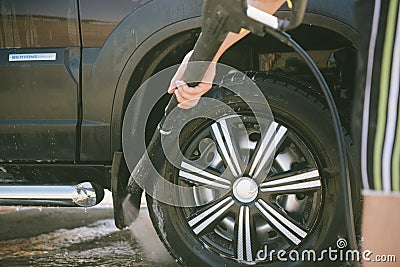 A man washes a car with a high pressure washer Stock Photo