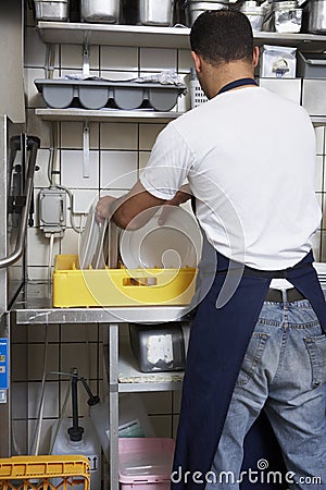 Man washing dishes Stock Photo