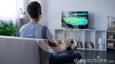 Man watching game on tv at home supporting one of soccer team, match result Stock Photo