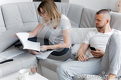 Man watching TV. Woman looking through documents Stock Photo