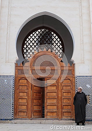 Man wearing arab djellaba next to Mosque entrance Editorial Stock Photo