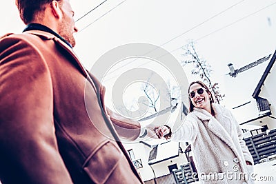 Man wearing brown coat holding hand of tender beautiful wife Stock Photo