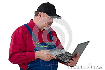 Man wearing dungarees holding laptop Stock Photo