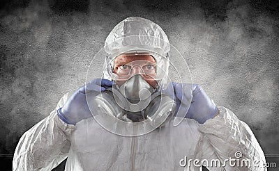 Man Wearing Hazmat Suit, Goggles and Gas Mask In Smokey Dark Room Stock Photo