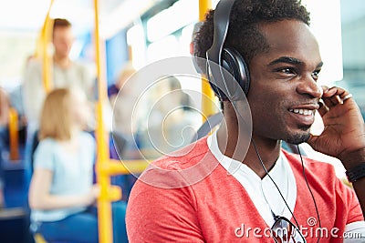 Man Wearing Headphones Listening To Music On Bus Journey Stock Photo