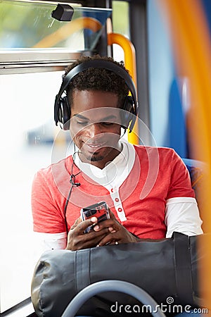 Man Wearing Headphones Listening To Music On Bus Journey Stock Photo