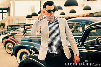 Man wearing jacket and shirt with old cars Stock Photo