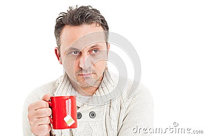 Man wearing knitted pullover holding a mug of hot tea Stock Photo