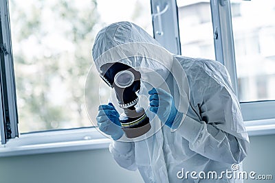Man wearing protective biological suit and gas-mask due to mers coronavirus global pandemic warning and danger. Medic sphysician Stock Photo
