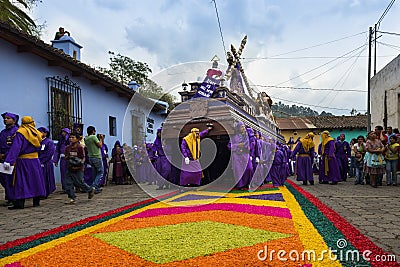 Man wearing purple robes, carrying a float anda during the Easter celebrations, in the Holy Week, in Antigua, Guatemala. Editorial Stock Photo