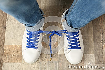 Man wearing sneakers with tied laces, top view. April fool`s day Stock Photo