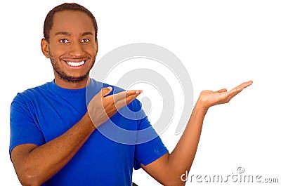 Man wearing strong blue t-shirt standing and interacting using hands simulating presentation while smiling, white studio Stock Photo