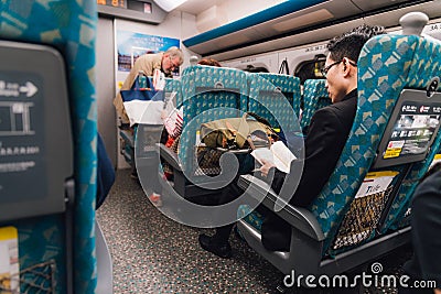 A man wearing suit reading and sitting in Taiwan High Speed Rail THSR in the morning in Taiwan, Taipei Editorial Stock Photo