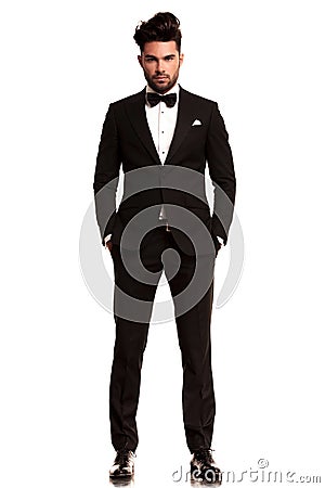 Man wearing tuxedo standing with hands in pockets Stock Photo