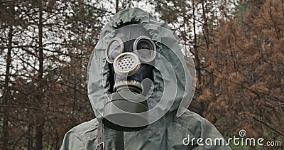 Man wearing a WWII Hazmat suit and gas mask carrying a counter in his hands as he scans for hazardous material in a Stock Photo