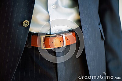 Man wears belt. Young businessman in casual suit with accessories. Fashion and clothing concept. Groom getting ready in Stock Photo