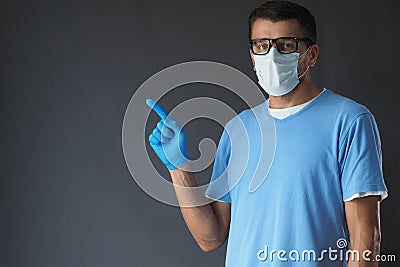 Man wears face mask blue latex glove, man pointing hand up. Stock Photo