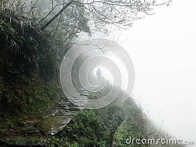 man at wet pathway on hill slope in rain Stock Photo